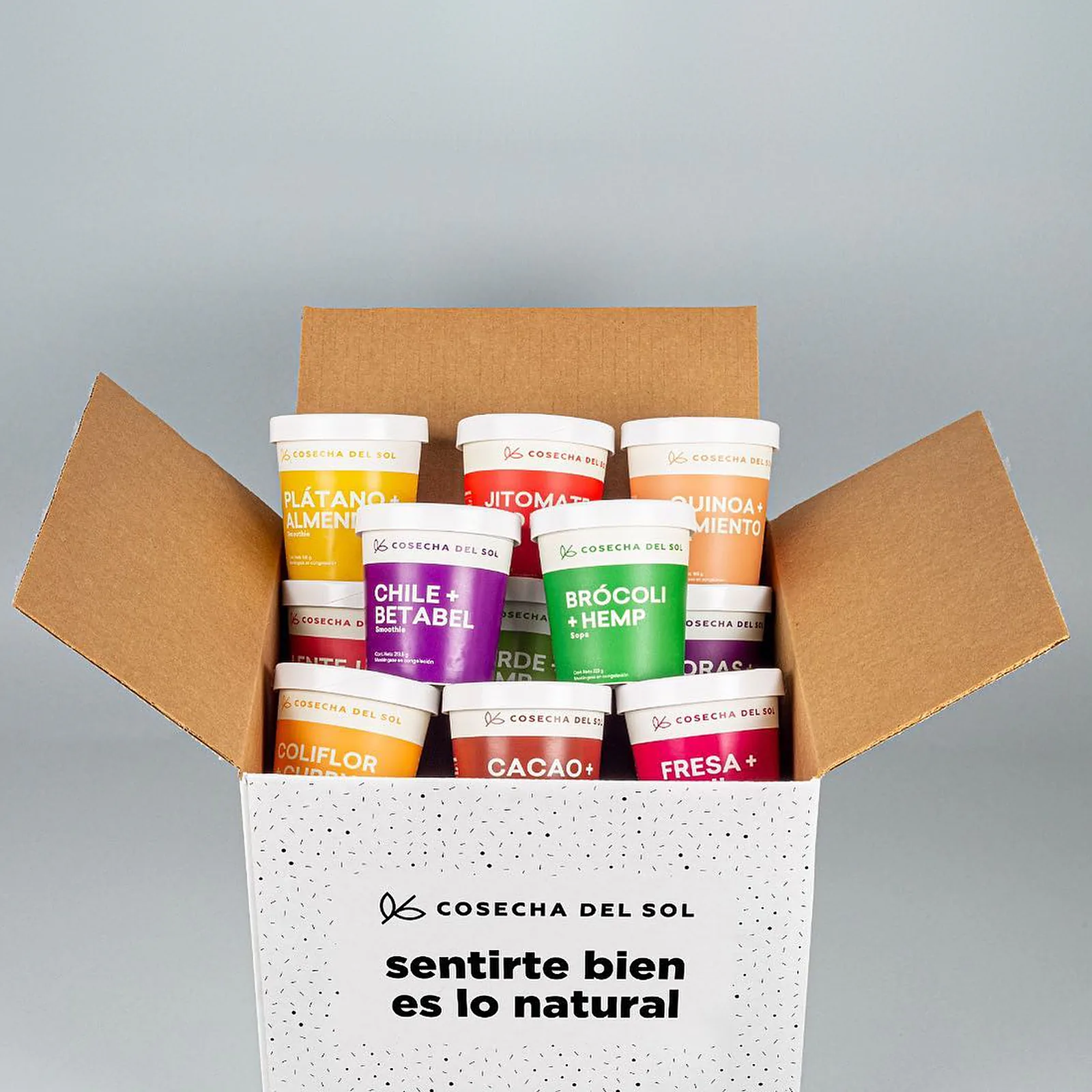 Caja abierta con empaques de colores y la frase “sentirte bien es lo natural”.